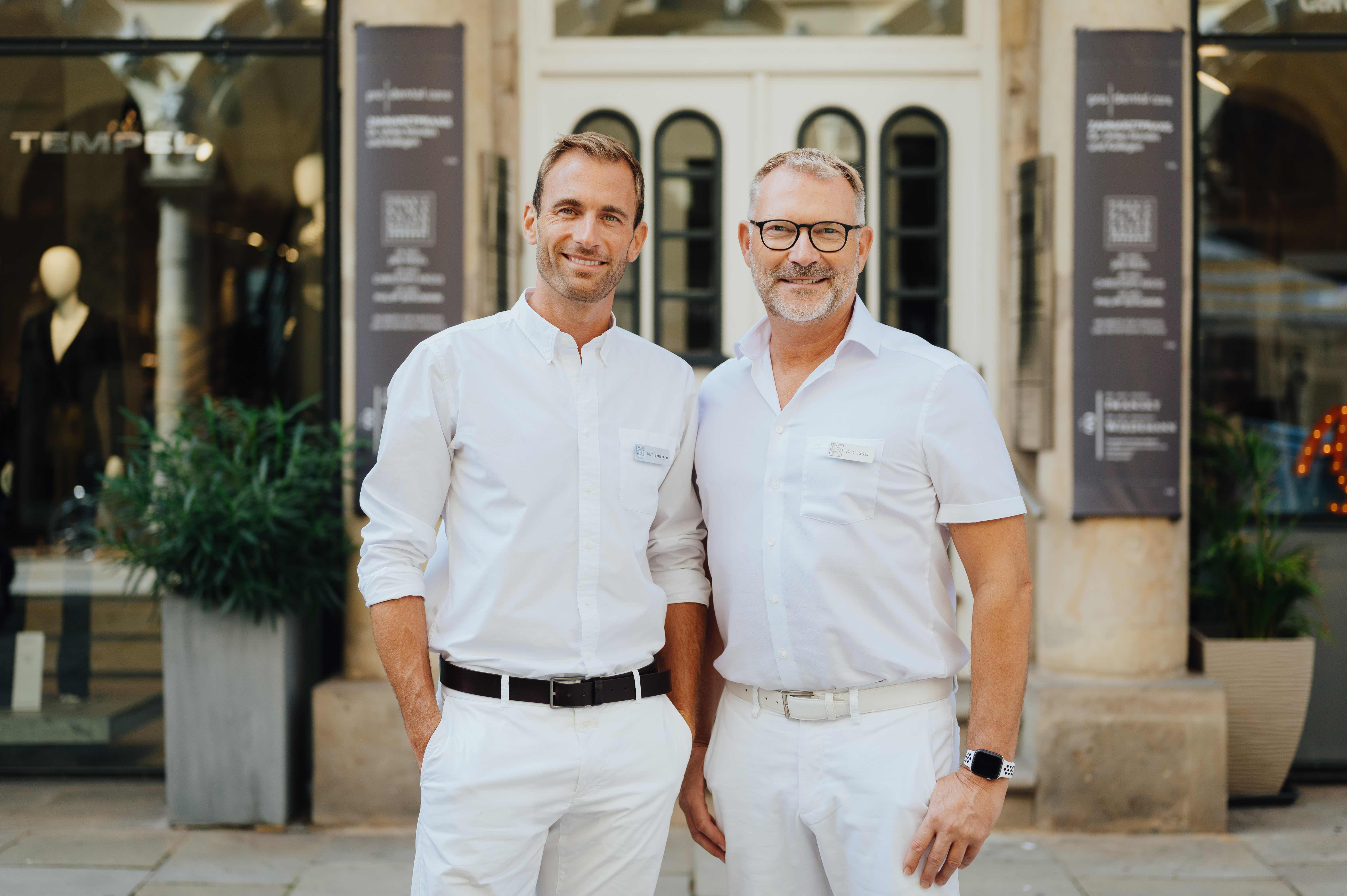 Dr. Bergmann und Dr. Kruess stehen nebeneinander vor der Praxisklinik - Colonnaden in Hamburg.