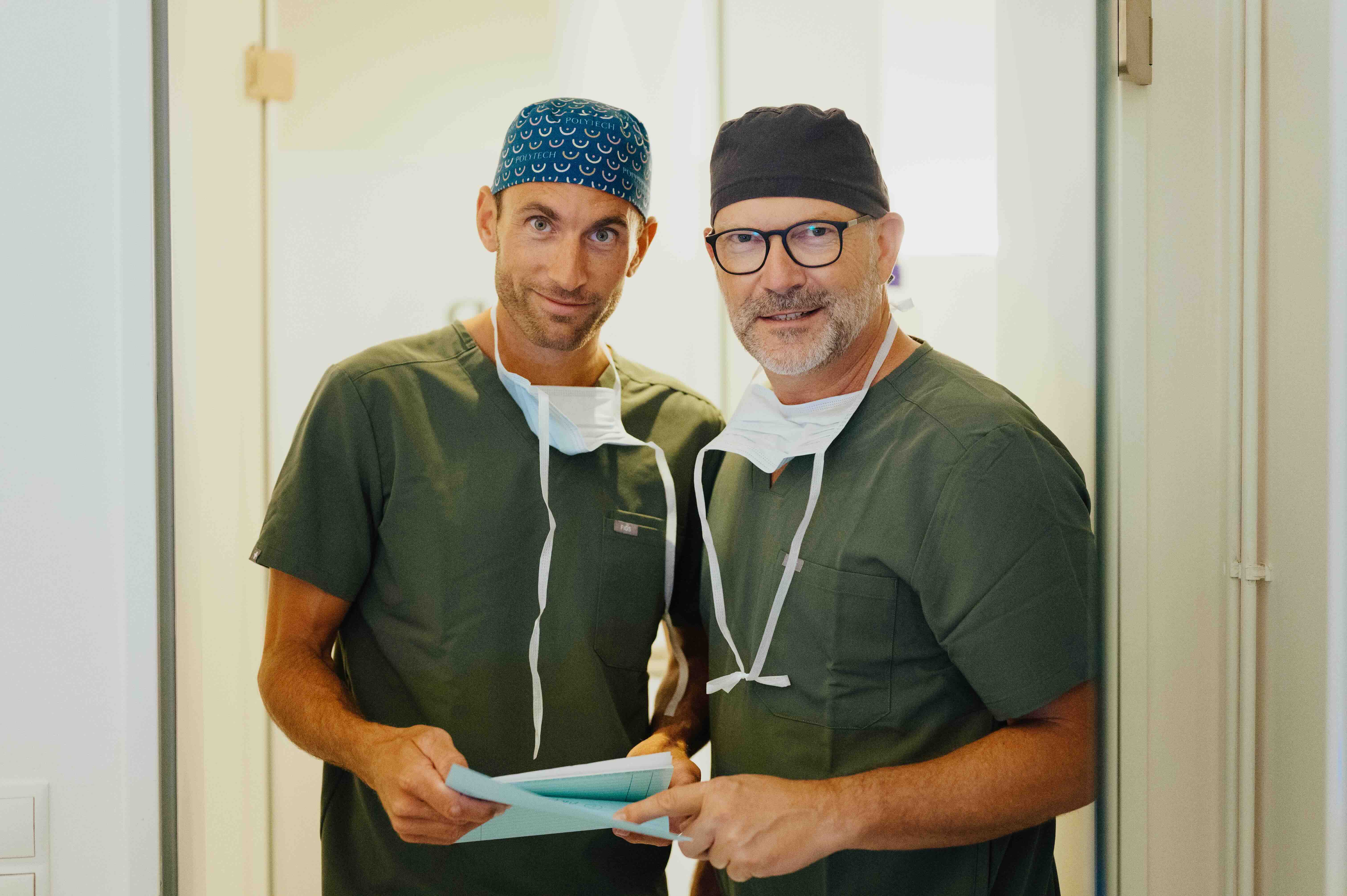 Dr. Bergmann und Dr. Kruess stehen nebeneinander und besprechen gemeinsam eine Behandlung.